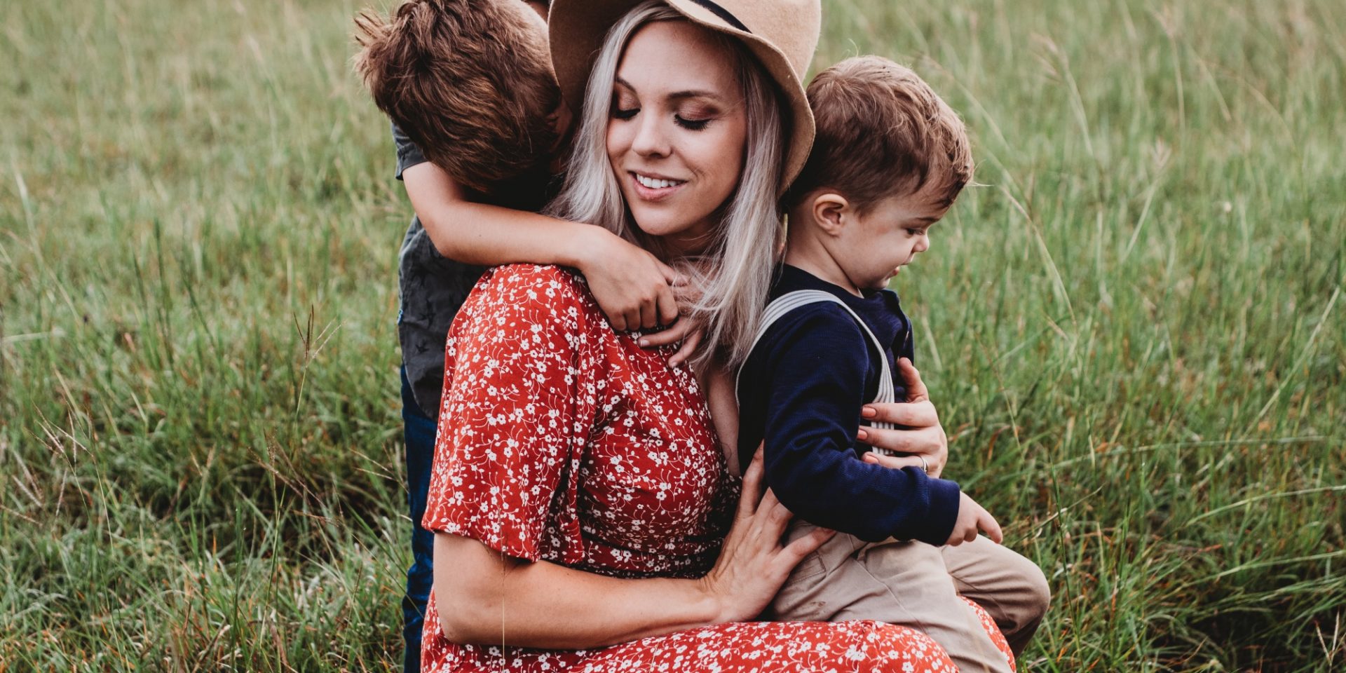 Nanny Au Pair sat with two boys in field