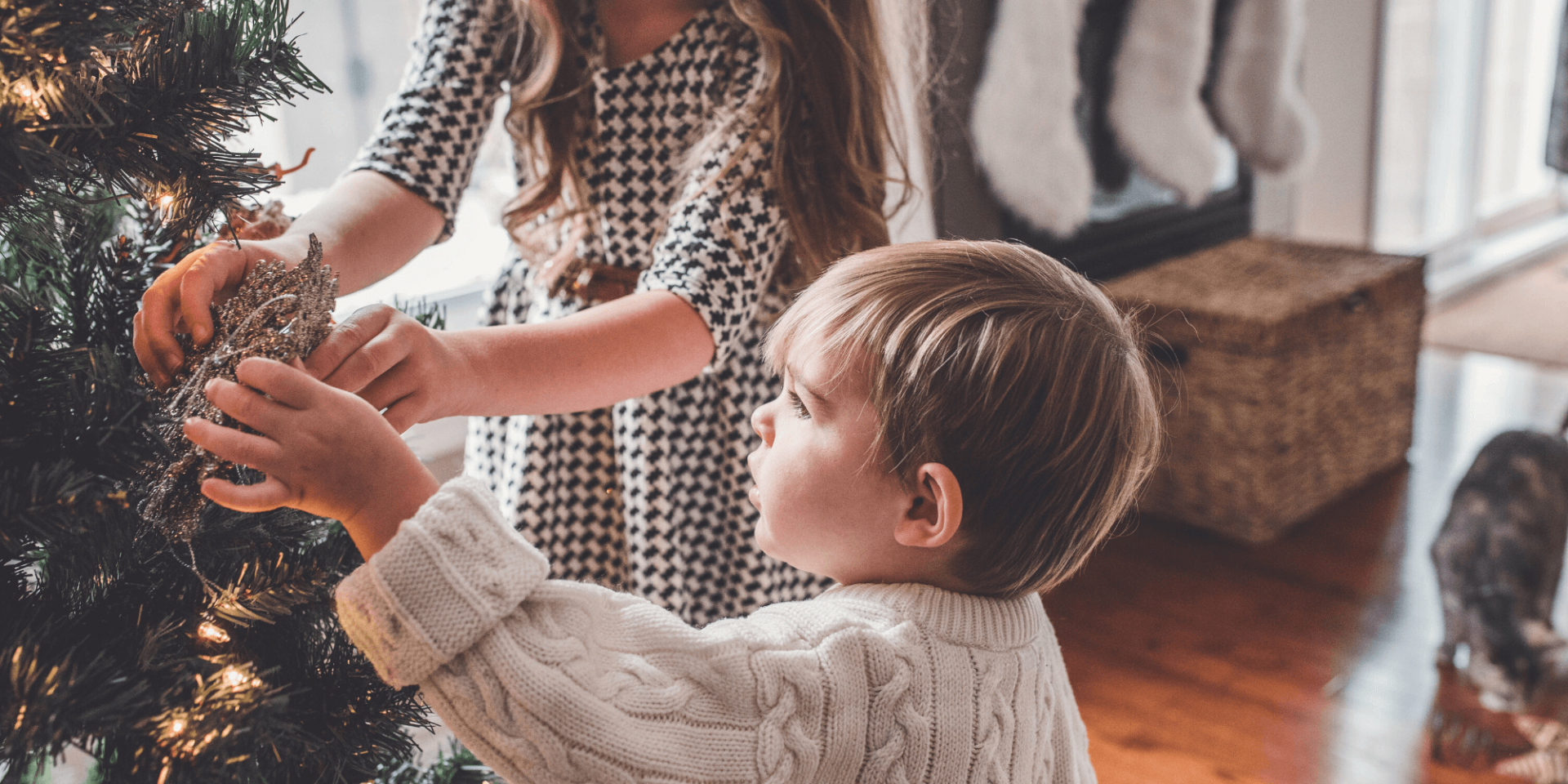 two small children hanging decorations on the Christmas tree